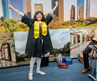 A happy JA student in a cap and gown.